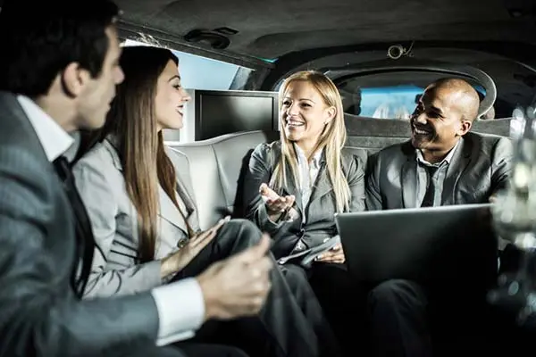 A picture of businesspeople chatting, laughing, and having fun inside one of our luxury vehicles