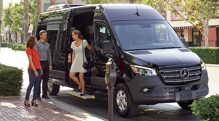 A picture of customers walking out of one of out luxury sprinters after dropping them off at their destination